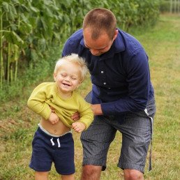 father and son playing in grass field