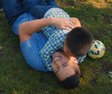 father and son playing in the grass