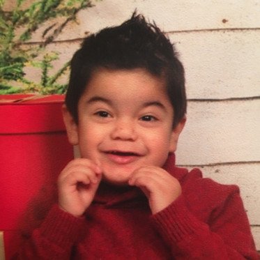 toddler boy smiling in red turtle neck sweater