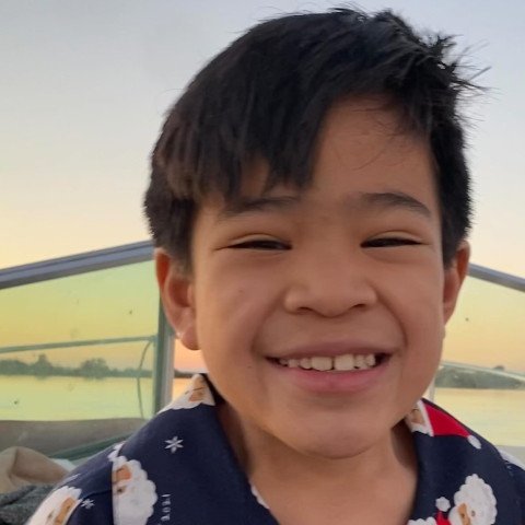 Noah smiling in Santa pajamas on boat